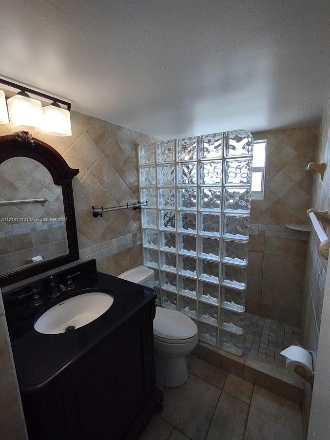 a bathroom with a sink a toilet a mirror and shower