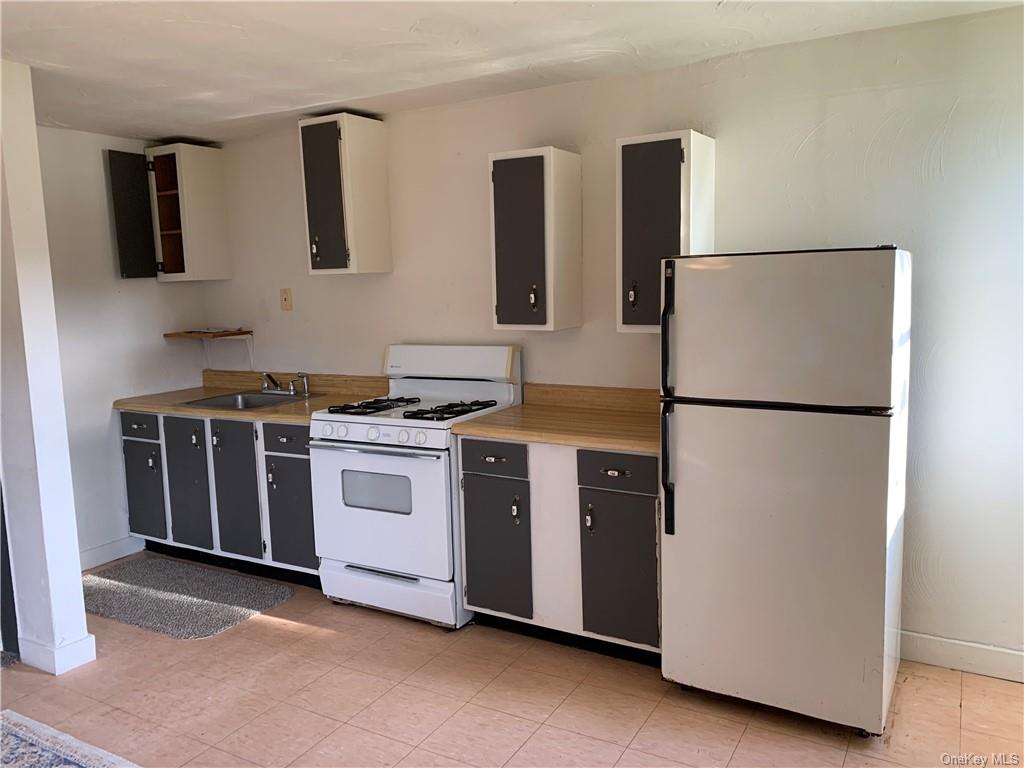 22 Arrowhead Apartments Road Narrowsburg, NY 12764 - Photo 19 of 34 a kitchen with stainless steel appliances white cabinets and a refrigerator