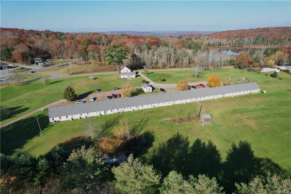an aerial view of residential houses with outdoor space and trees