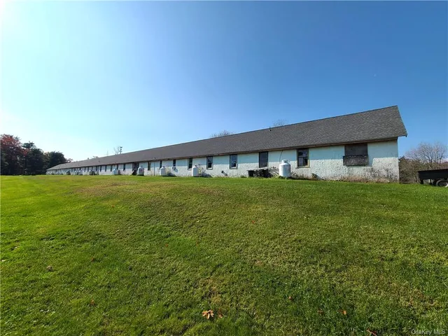an aerial view of green landscape with trees houses and mountain view