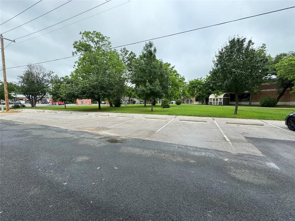 112 Lexington Road Elgin, TX 78621 - Photo 1 of 1 a view of a road with a big yard and large trees