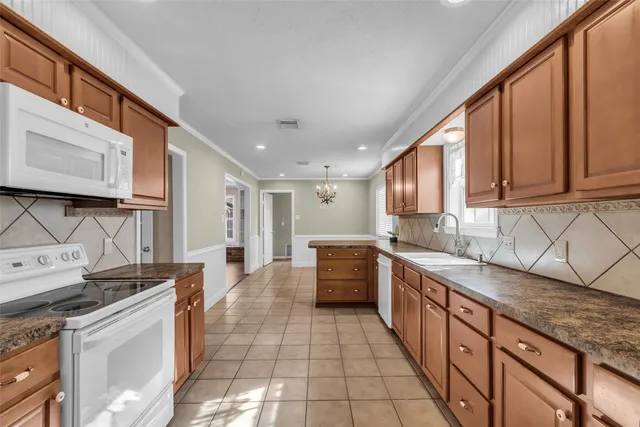 a large kitchen with stainless steel appliances granite countertop a sink and cabinets