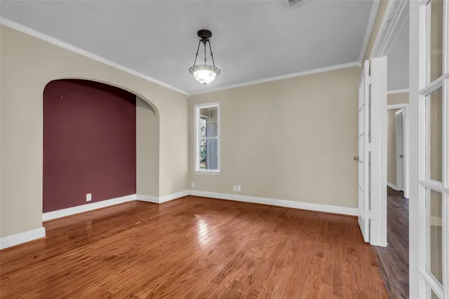 a view of an empty room with wooden floor