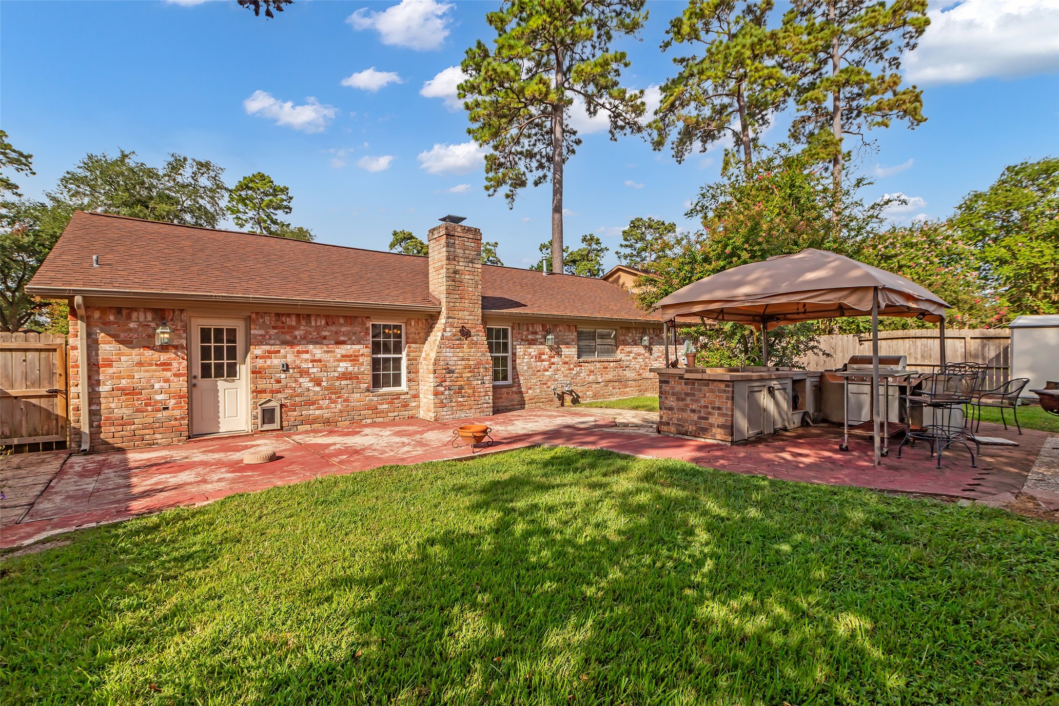 23826 Farm Hill Drive Spring, TX 77373 - Photo 35 of 38 a patio with a table and chairs under an umbrella
