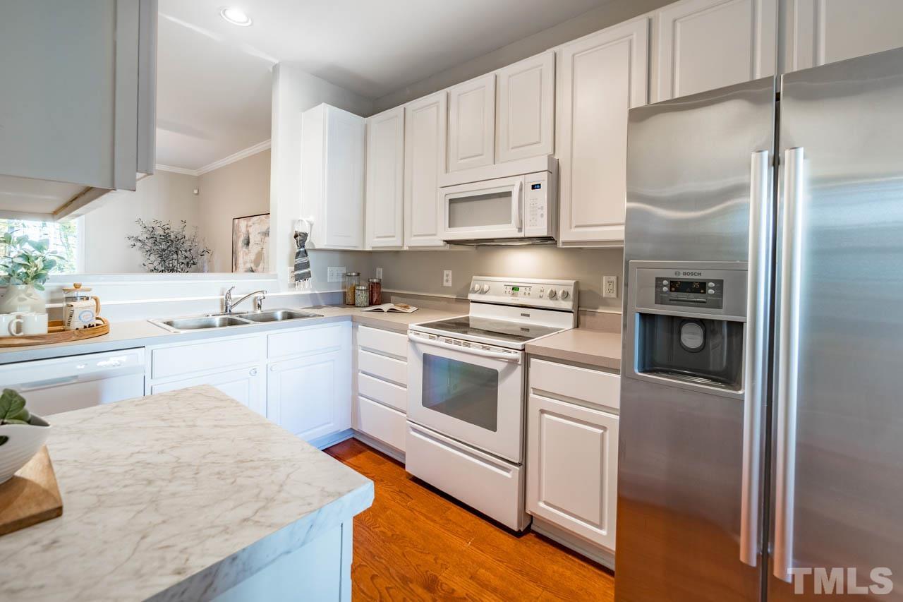 8453 Reedy Ridge Lane Raleigh, NC 27613 - Photo 4 of 21 a kitchen with white cabinets and white appliances
