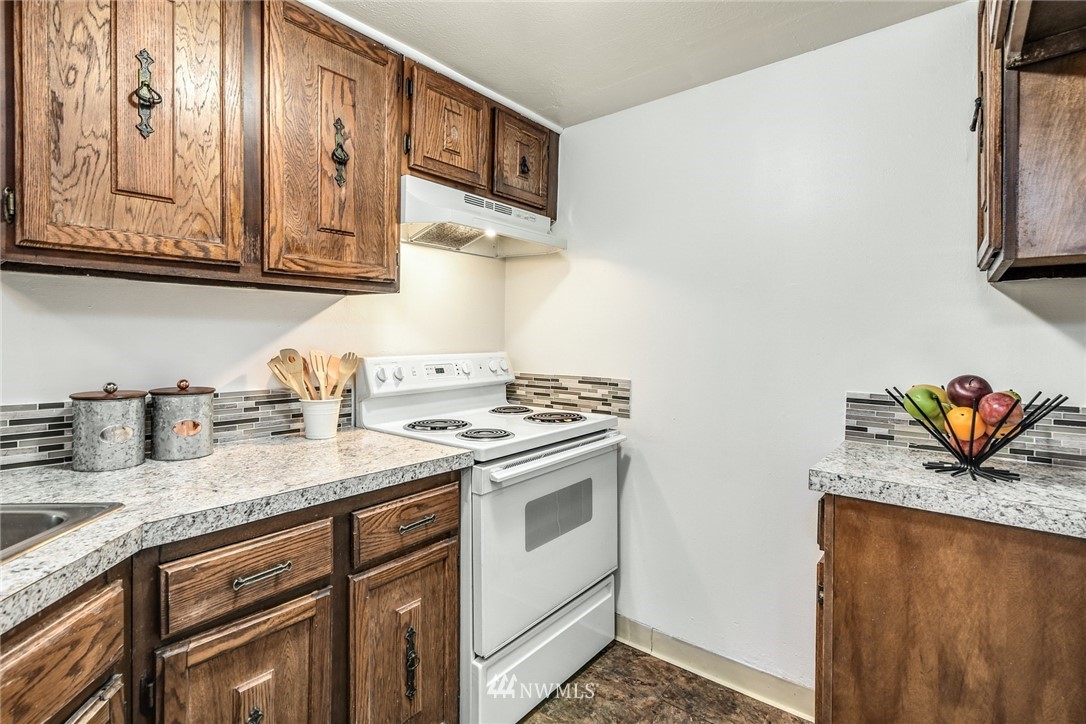 7511 14th Avenue Southwest Seattle, WA 98106 - Photo 5 of 16 a kitchen with stainless steel appliances granite countertop a sink stove and cabinets