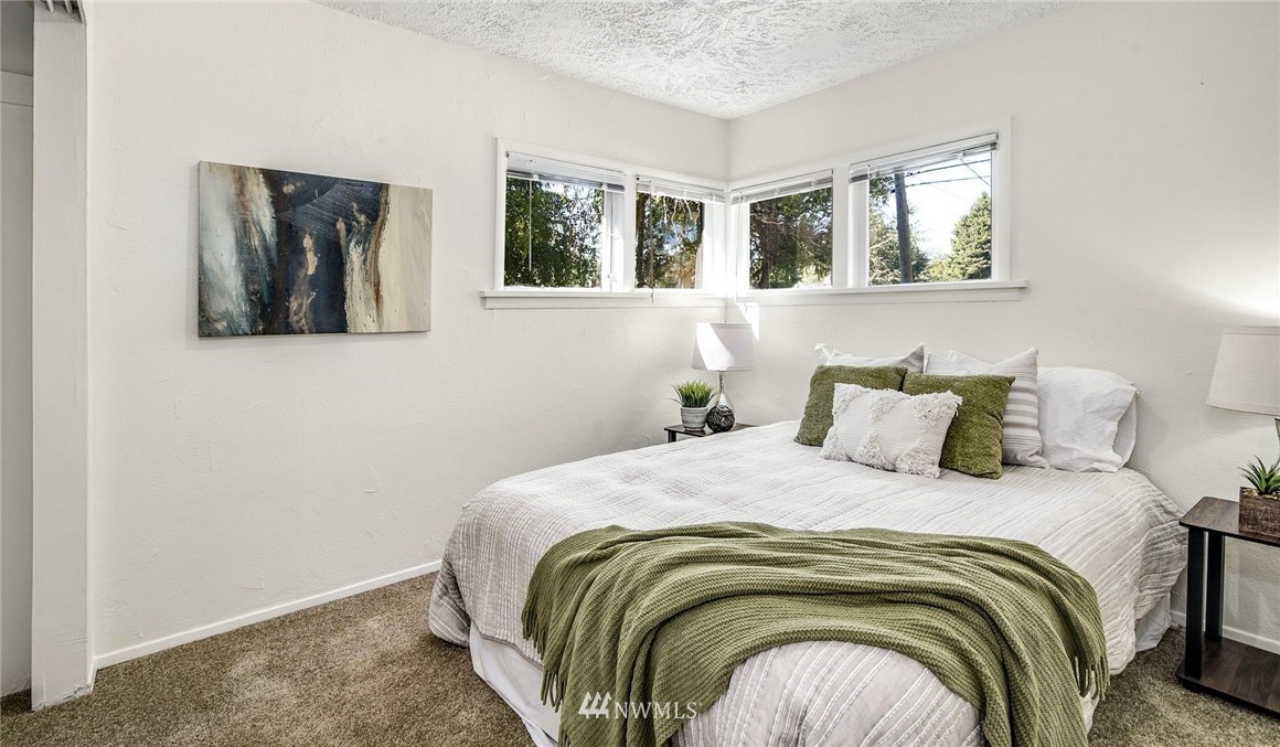 7511 14th Avenue Southwest Seattle, WA 98106 - Photo 8 of 16 a bedroom with a bed and glass window