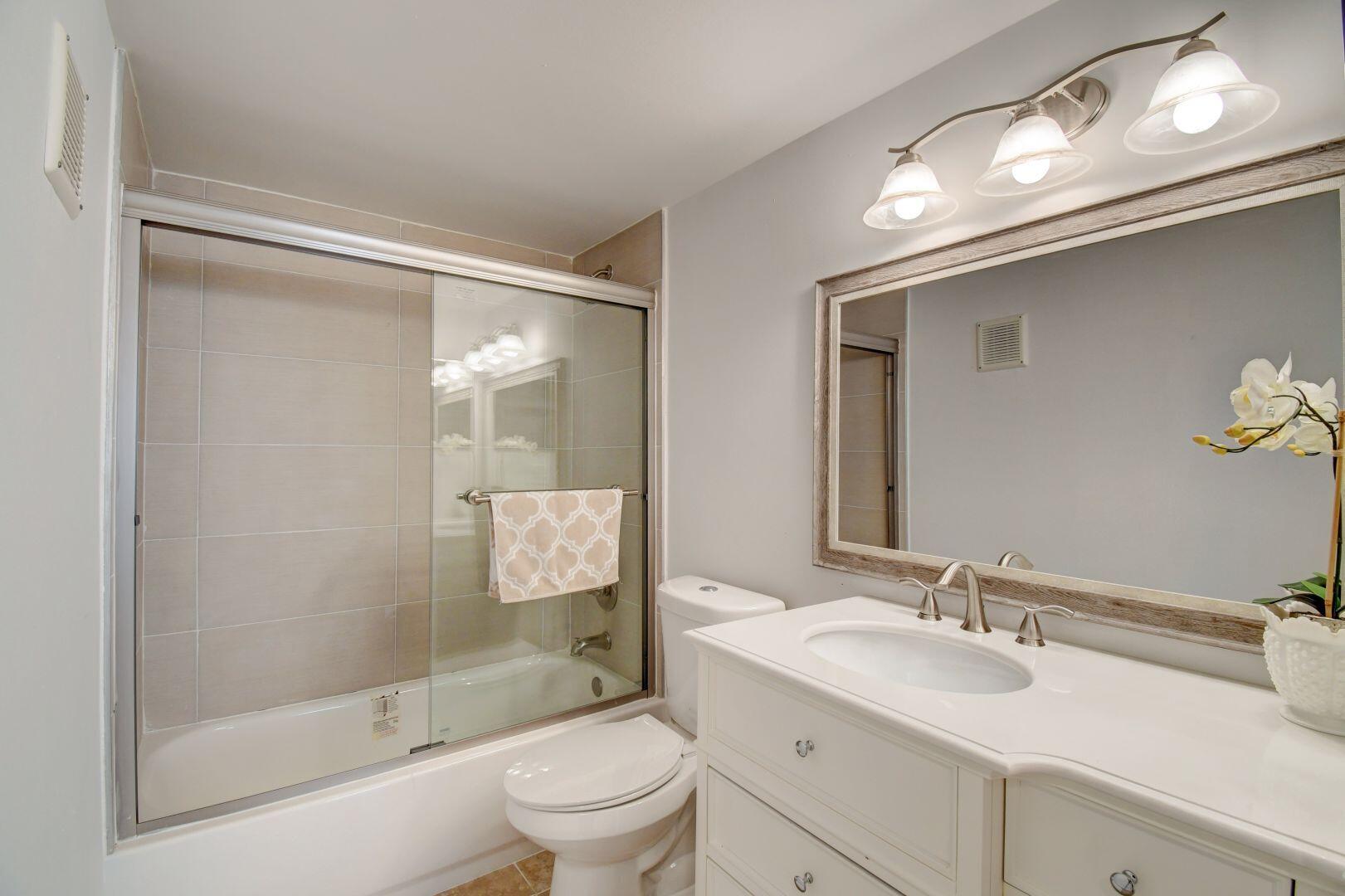 15364 Lakes Of Delray Boulevard, Unit 45 Delray Beach, FL 33484 - Photo 11 of 56 a bathroom with a sink a toilet and shower