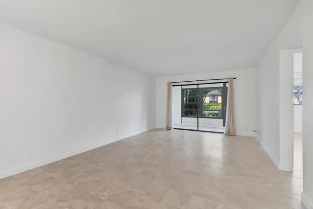 a view of an empty room with window and front door