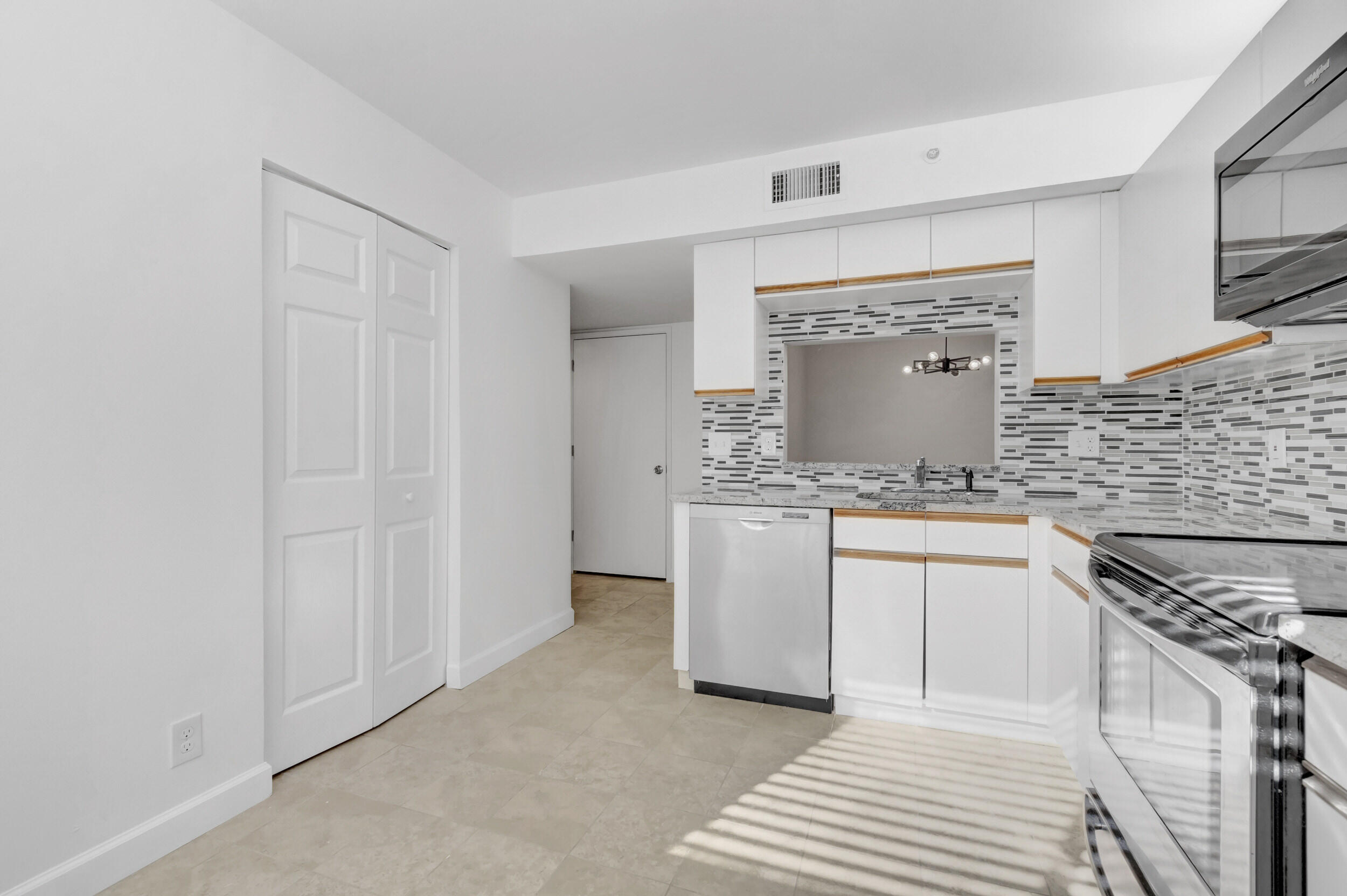 15364 Lakes Of Delray Boulevard, Unit 45 Delray Beach, FL 33484 - Photo 27 of 56 a kitchen with granite countertop white cabinets and white appliances