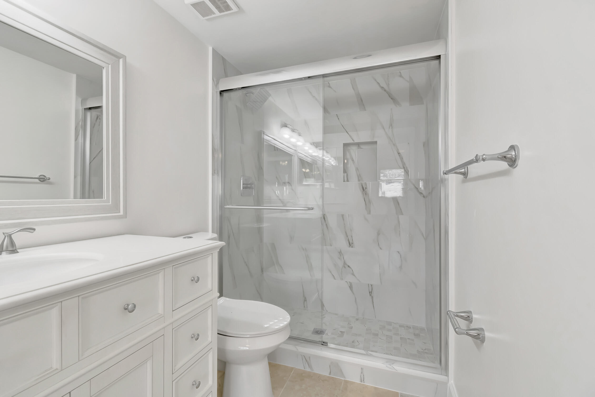 15364 Lakes Of Delray Boulevard, Unit 45 Delray Beach, FL 33484 - Photo 36 of 56 a bathroom with a shower sink vanity mirror and toilet