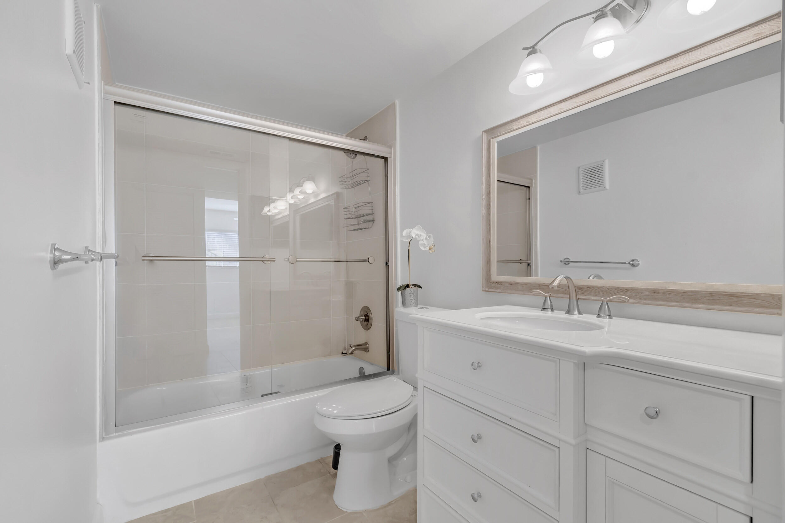 15364 Lakes Of Delray Boulevard, Unit 45 Delray Beach, FL 33484 - Photo 38 of 56 a bathroom with a shower sink vanity mirror and toilet