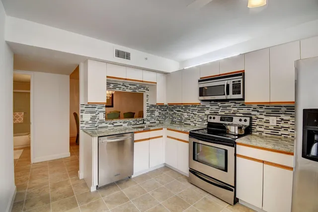 a kitchen with stainless steel appliances granite countertop a stove and a microwave