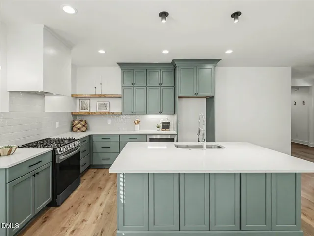 a kitchen with kitchen island granite countertop a sink stove and refrigerator
