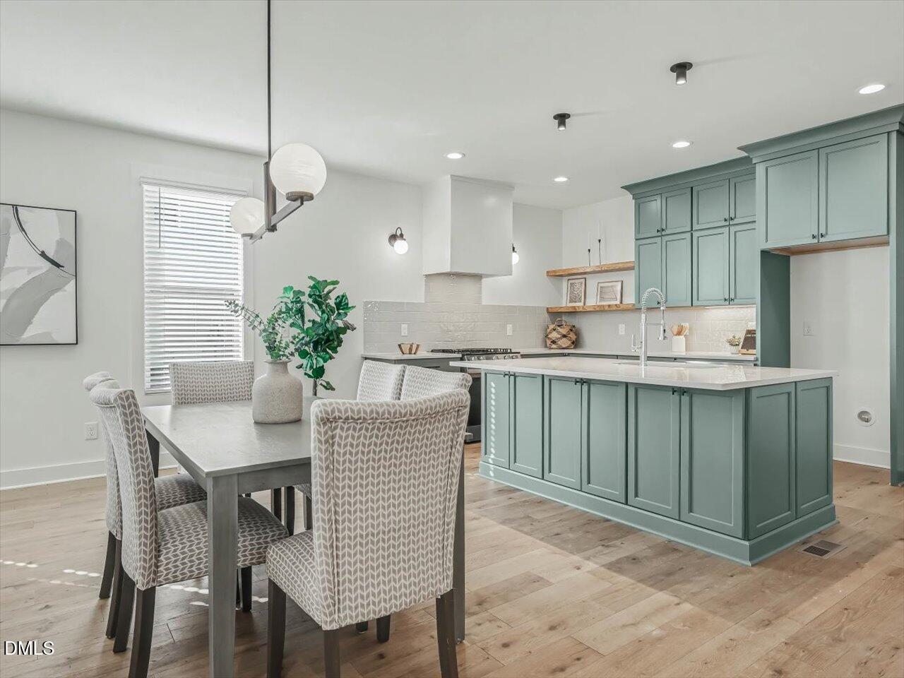 2312 Broad Street Durham, NC 27704 - Photo 17 of 53 a kitchen with kitchen island a sink table and chairs