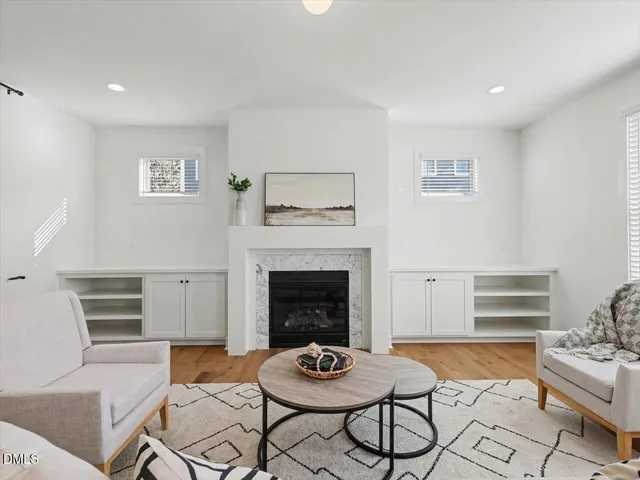 a living room with furniture kitchen view and a chandelier