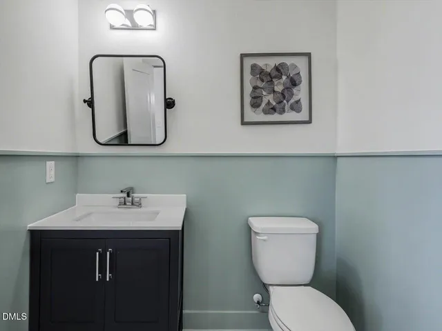 a bathroom with a toilet a sink and mirror