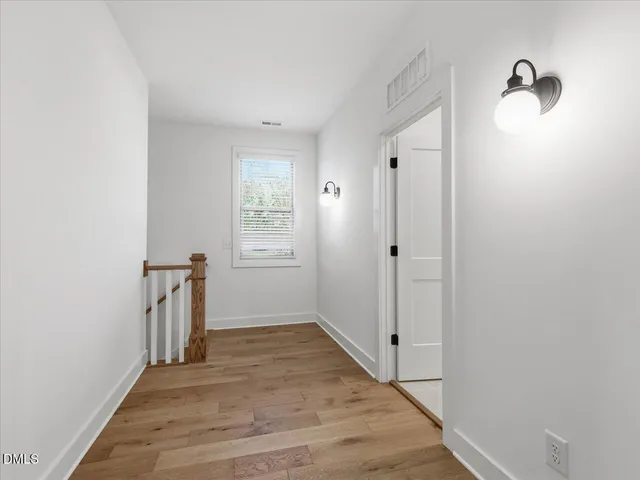 a view of hallway with wooden floor