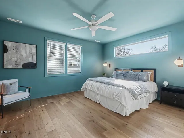 a bedroom with a large bed and a chandelier