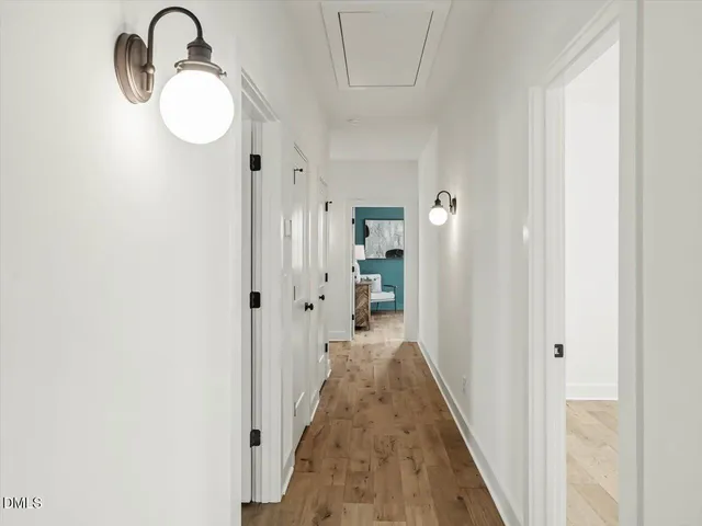 a view of a hallway with wooden floor and closet