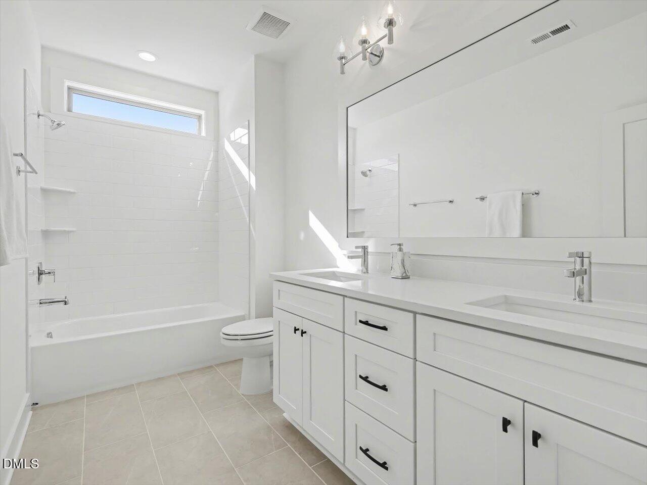 2312 Broad Street Durham, NC 27704 - Photo 48 of 53 a bathroom with a double vanity sink a toilet and a tub