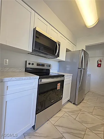 a kitchen with granite countertop a stove and a microwave