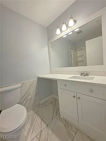 a bathroom with a sink mirror vanity and toilet