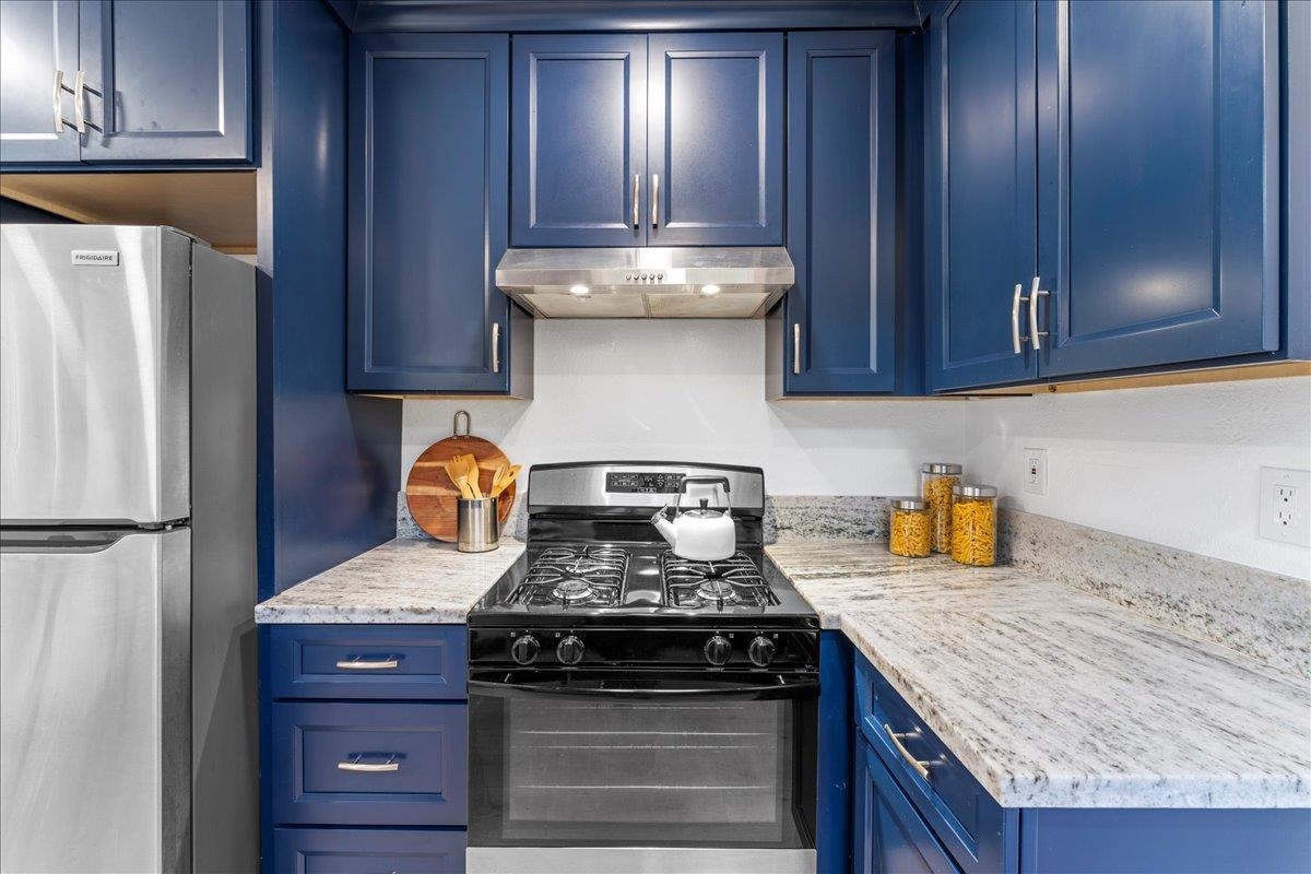 2717 Mabel Street Berkeley, CA 94702 - Photo 19 of 59 Kitchen with blue cabinets, stainless steel appliances, and light stone counters