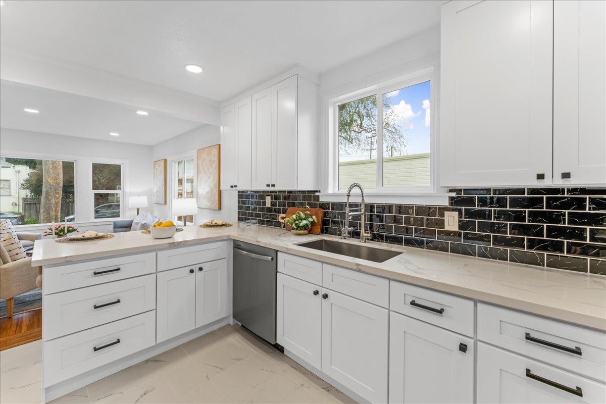 2717 Mabel Street Berkeley, CA 94702 - Photo 59 of 59 Kitchen featuring white cabinetry, backsplash, light stone counters, a peninsula, and open floor plan