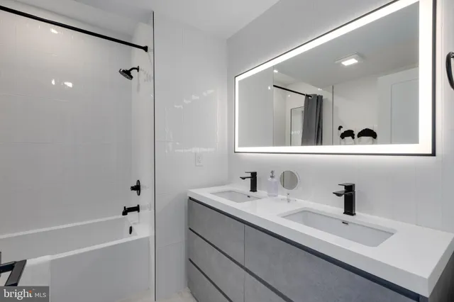 a bathroom with a bathtub a sink a mirror and a shower
