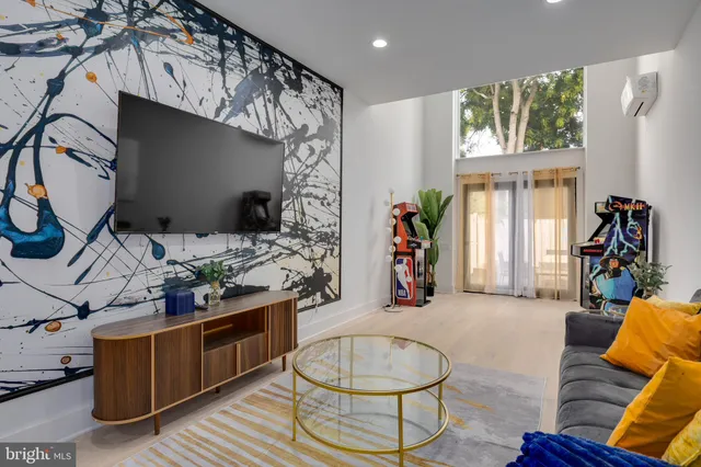 a living room with furniture a window and a flat screen tv