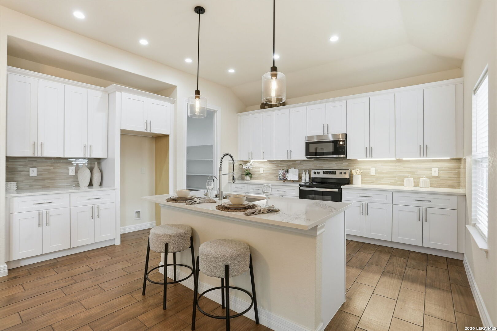 100 West Short Meadow Drive Lytle, TX 78052 - Photo 20 of 51 a kitchen with kitchen island granite countertop a sink a counter space appliances and cabinets