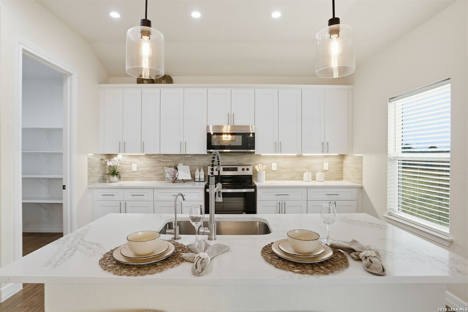 100 West Short Meadow Drive Lytle, TX 78052 - Photo 21 of 51 a kitchen with a sink stove and white cabinets