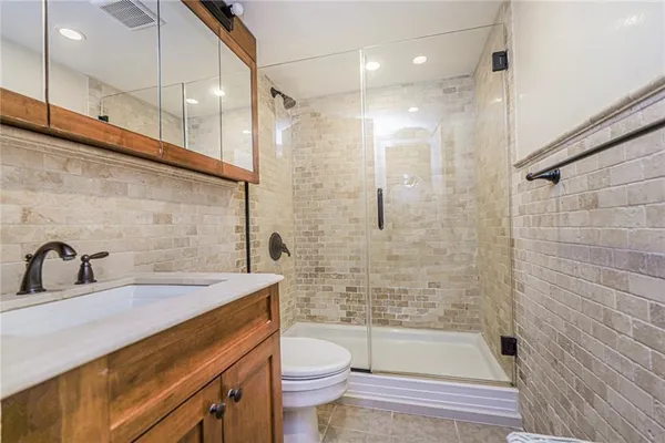 a bathroom with a sink a toilet and shower