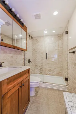 a bathroom with a sink a toilet and shower