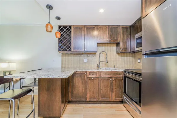 a kitchen with stainless steel appliances granite countertop a sink a stove and a refrigerator