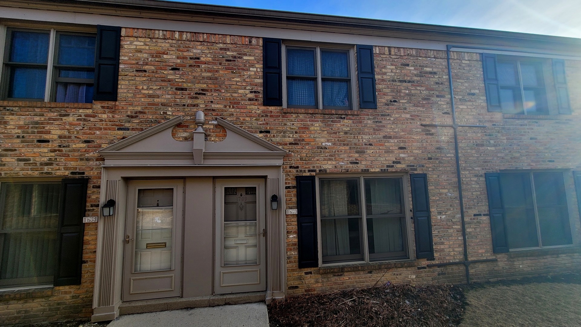a view of a brick house with large windows