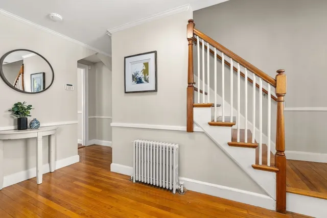 a view of a hallway with an entryway and wooden floor