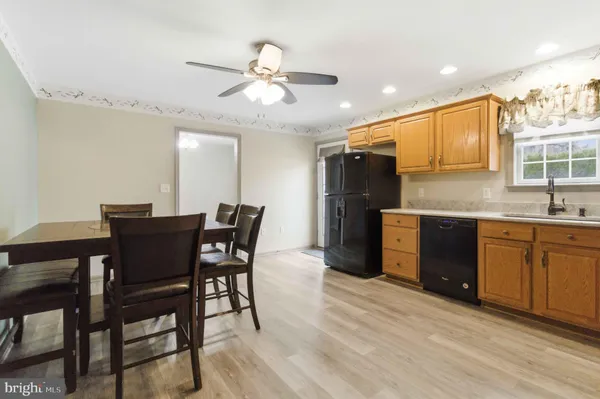 a kitchen with stainless steel appliances kitchen island granite countertop a table chairs sink and cabinets