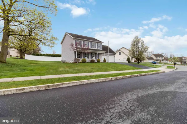 a view of a house with a big yard and large trees