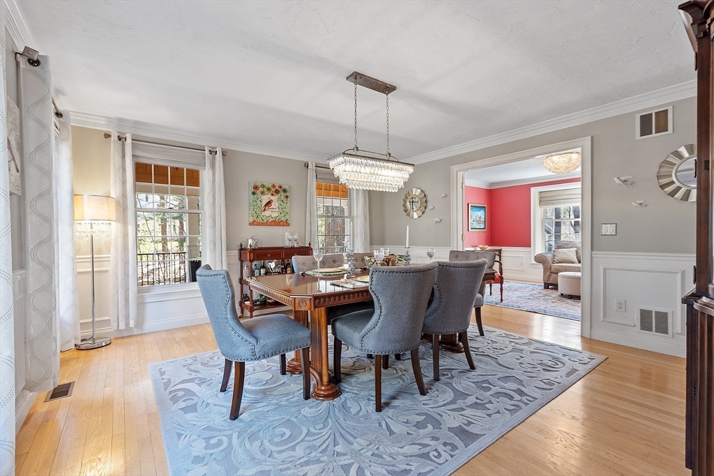 142 Pope Road Acton, MA 01720 - Photo 17 of 42 a dining room with wooden floor a chandelier a wooden table and chairs
