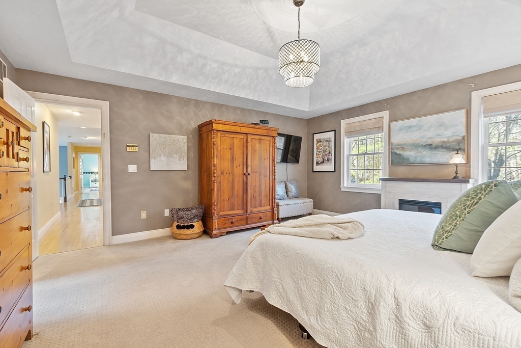 142 Pope Road Acton, MA 01720 - Photo 26 of 42 a spacious bedroom with a bed and a chandelier