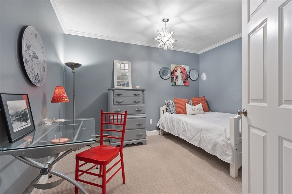 142 Pope Road Acton, MA 01720 - Photo 35 of 42 a bedroom with a bed and a chandelier