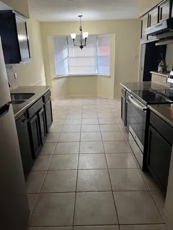 a kitchen with granite countertop a stove a sink and a counter top space