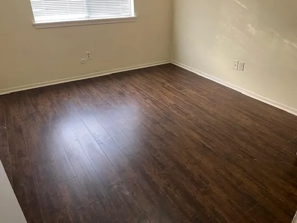 a view of a room with wooden floor and windows