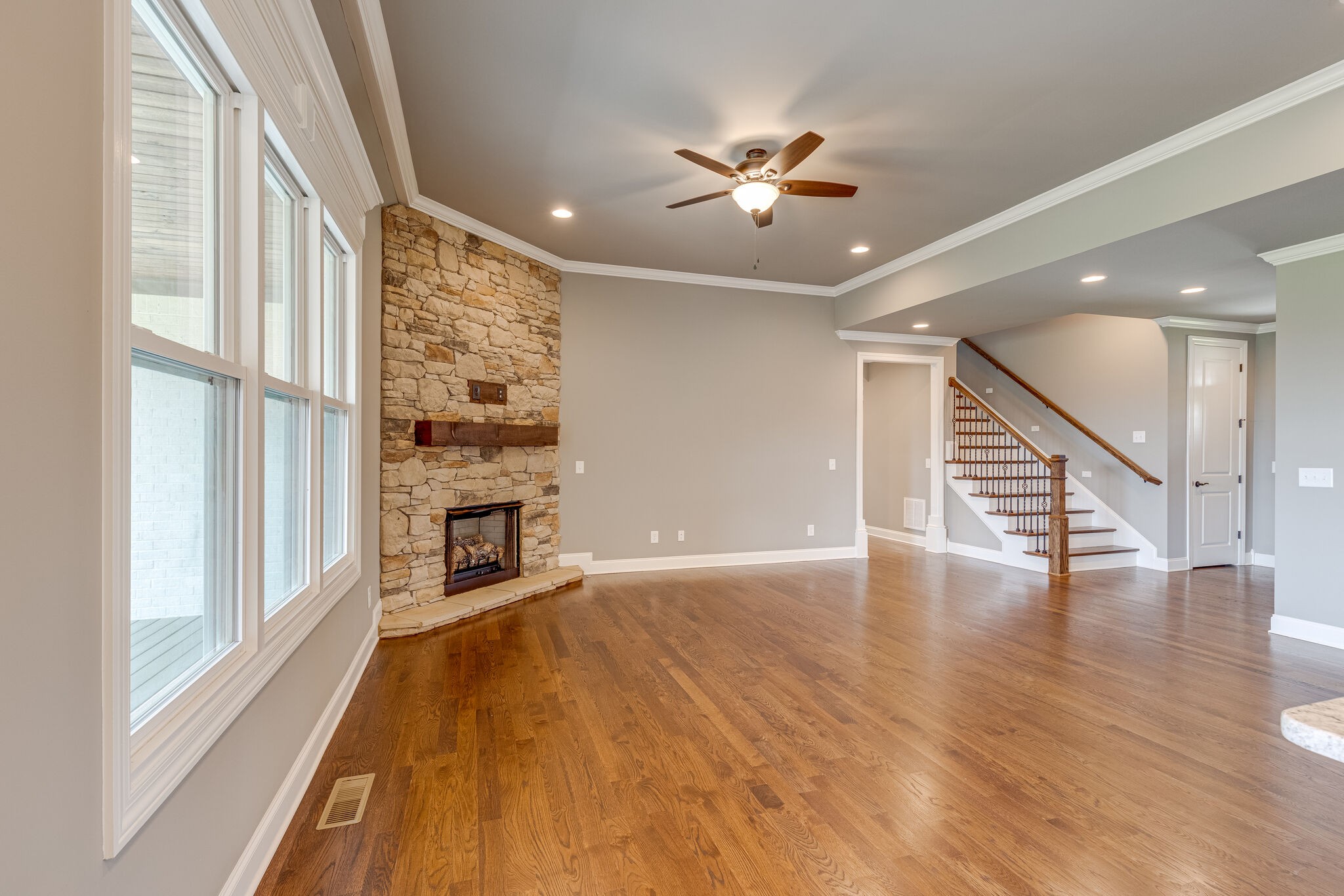 1029 Abbey Rd Way Spring Hill, TN 37174 - Photo 11 of 51 an empty room with wooden floor fireplace and windows