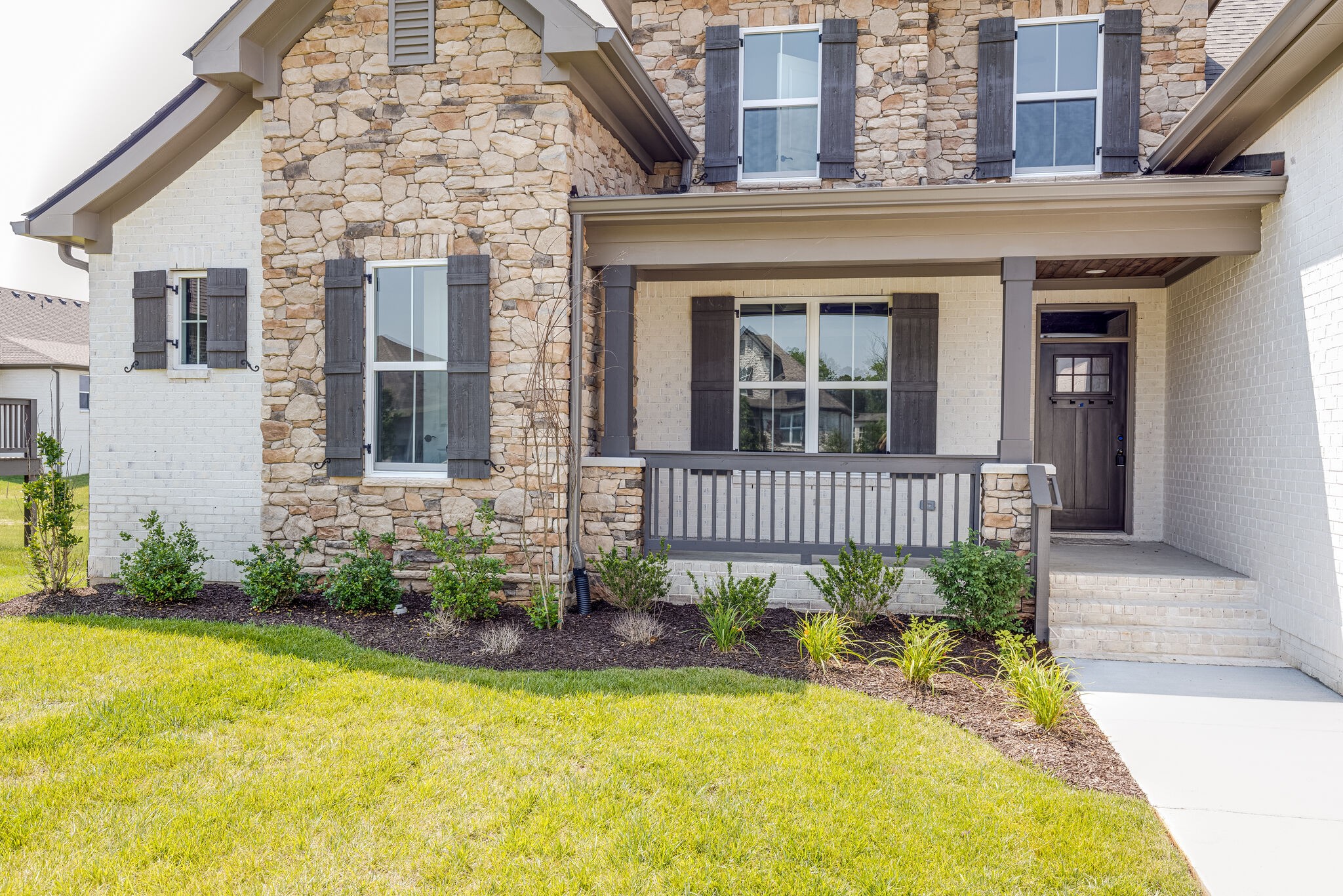 1029 Abbey Rd Way Spring Hill, TN 37174 - Photo 6 of 51 a view of a brick house with a small yard plants and large tree