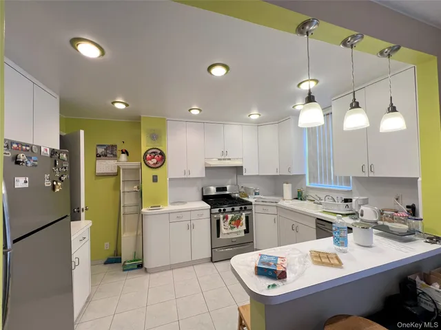 a kitchen with a sink a refrigerator and white cabinets