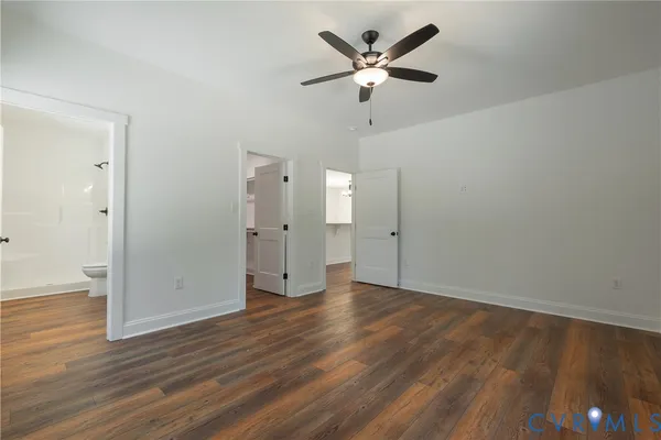 an empty room with wooden floor and ceiling fan
