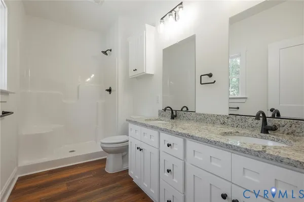 a bathroom with a granite countertop sink a toilet and a large mirror